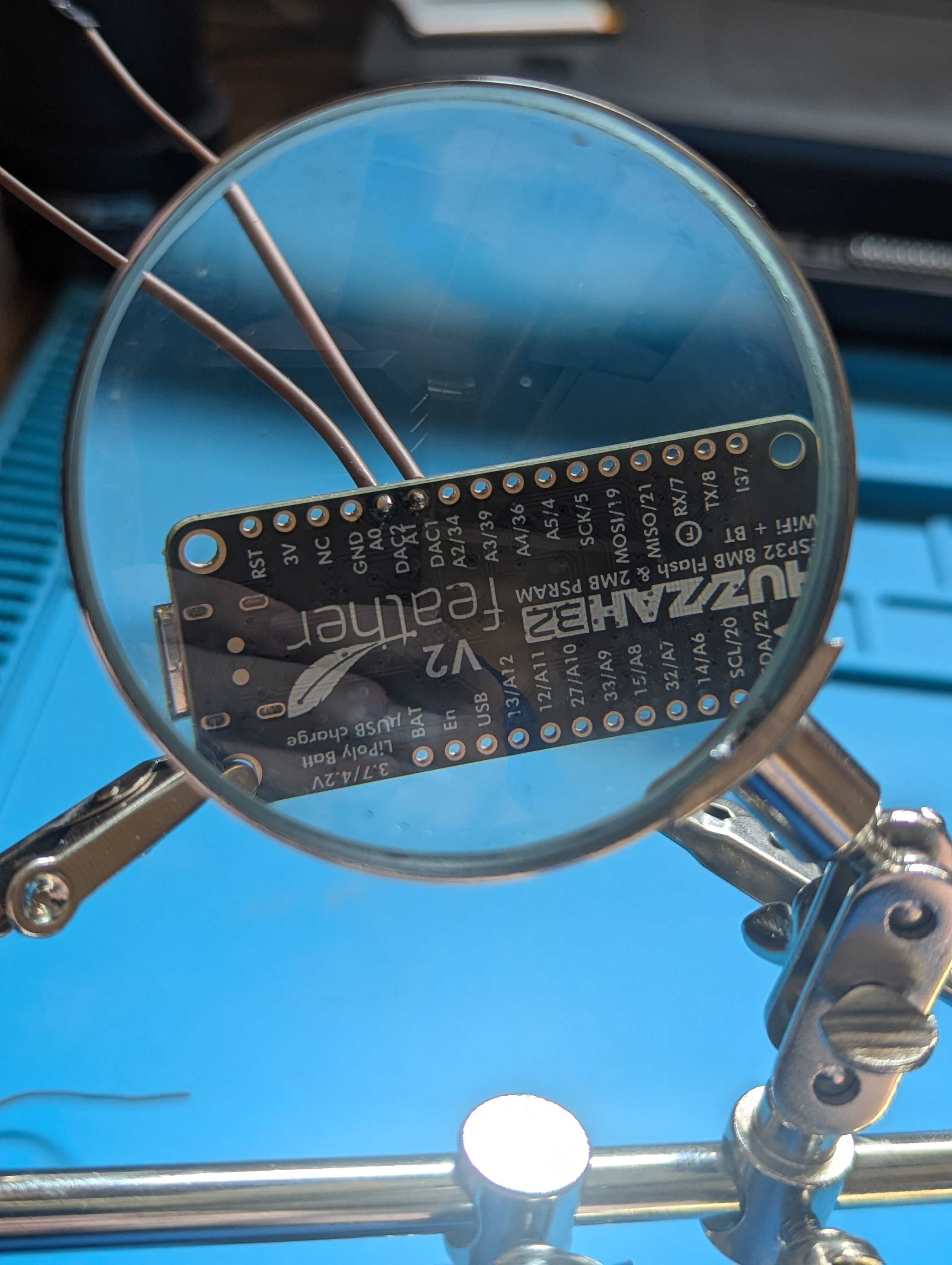 Feather ESP32 under magnifier, being soldered