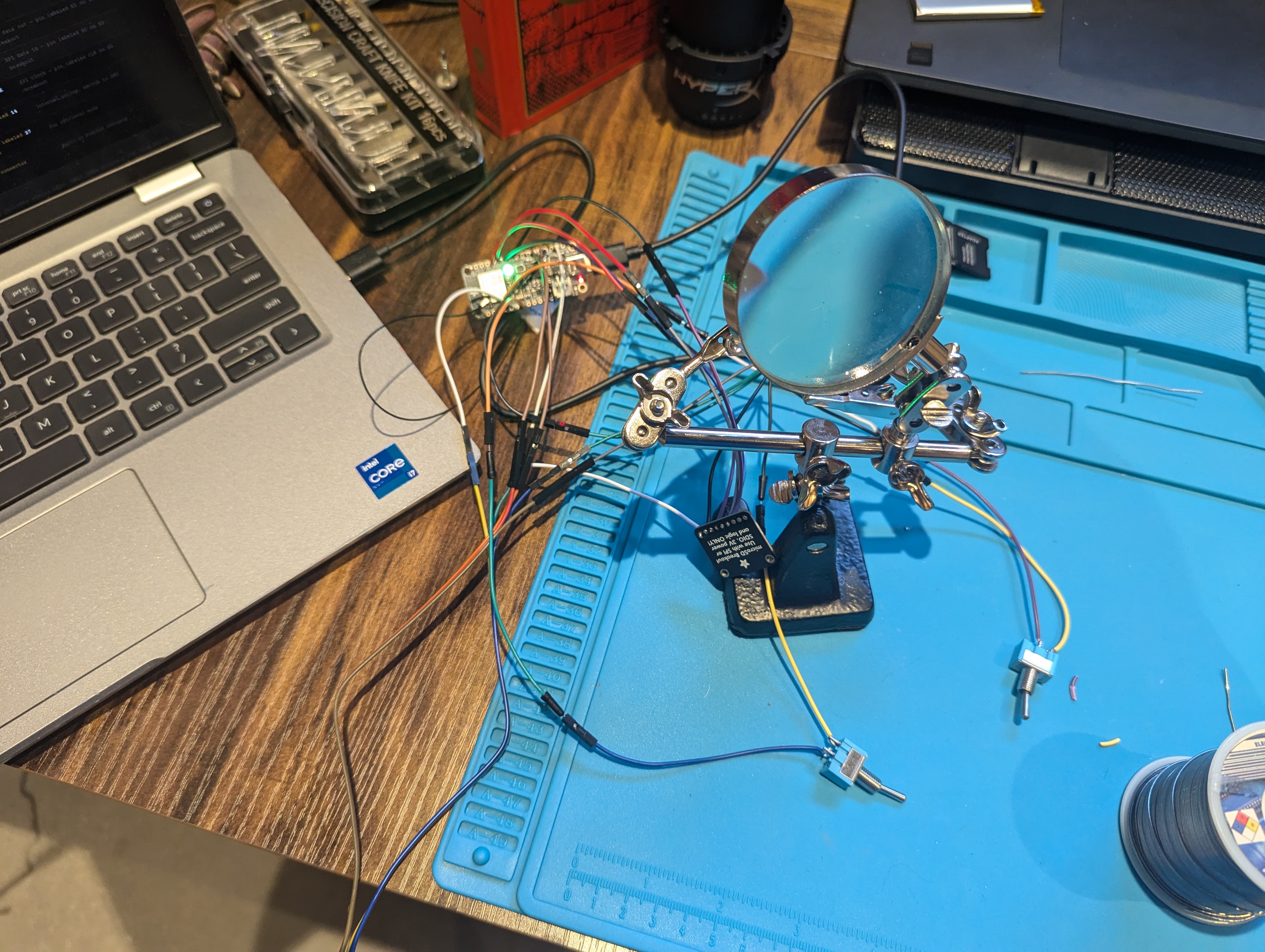 Wired components on soldering mat, ESP32 connected to laptop for firmware upload