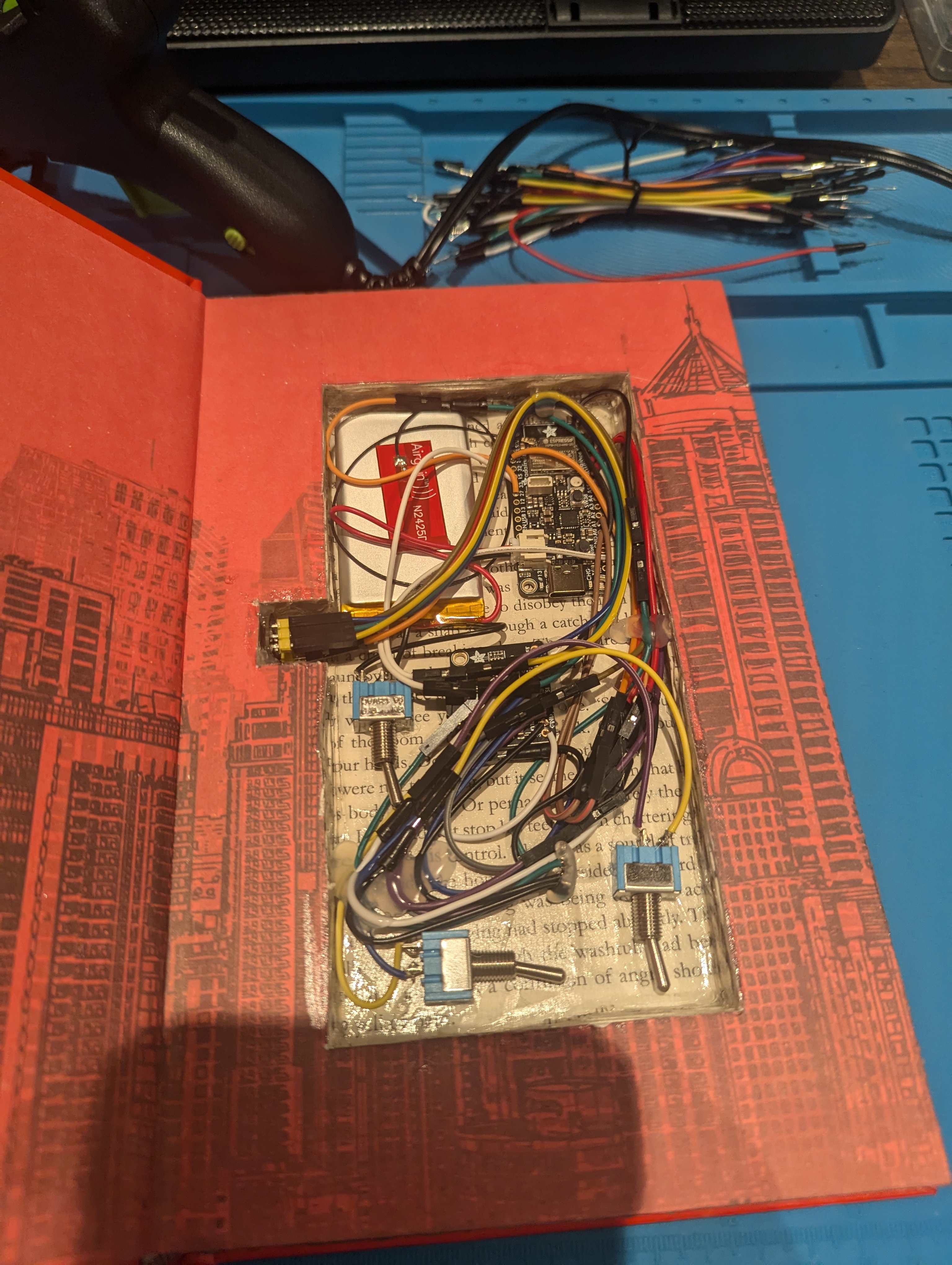 All components mounted inside book cavity with wiring and hot glue